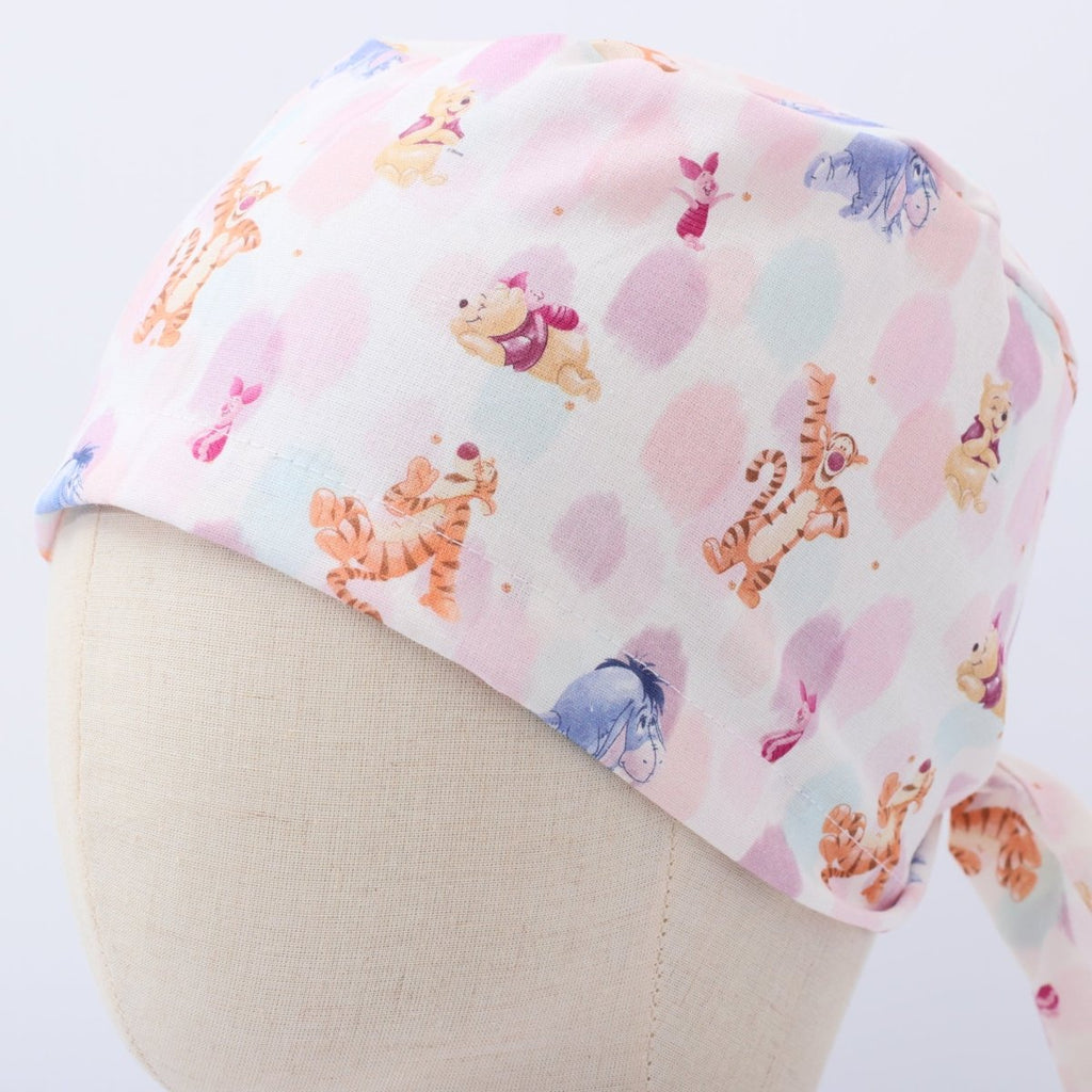 Custom pastel scrub cap by Medicus Caps featuring playful cartoon animals on white and pink background. Handmade to order, comfortable surgical cap with ties.