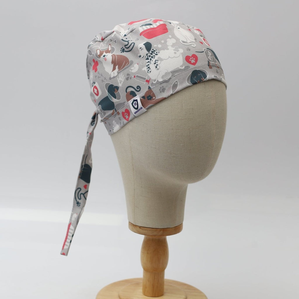 Side view of grey custom scrub cap featuring cartoon dogs and cats with hearts and bones. Handmade pet lover scrub cap by Medicus Caps with long tie strap, ideal for veterinary or medical professionals.