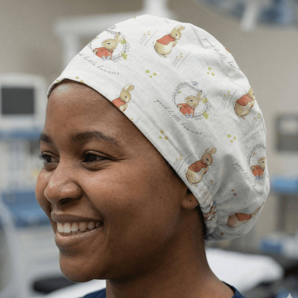 White Peter Rabbit cartoon pattern scrub cap with grey text and colourful illustrations