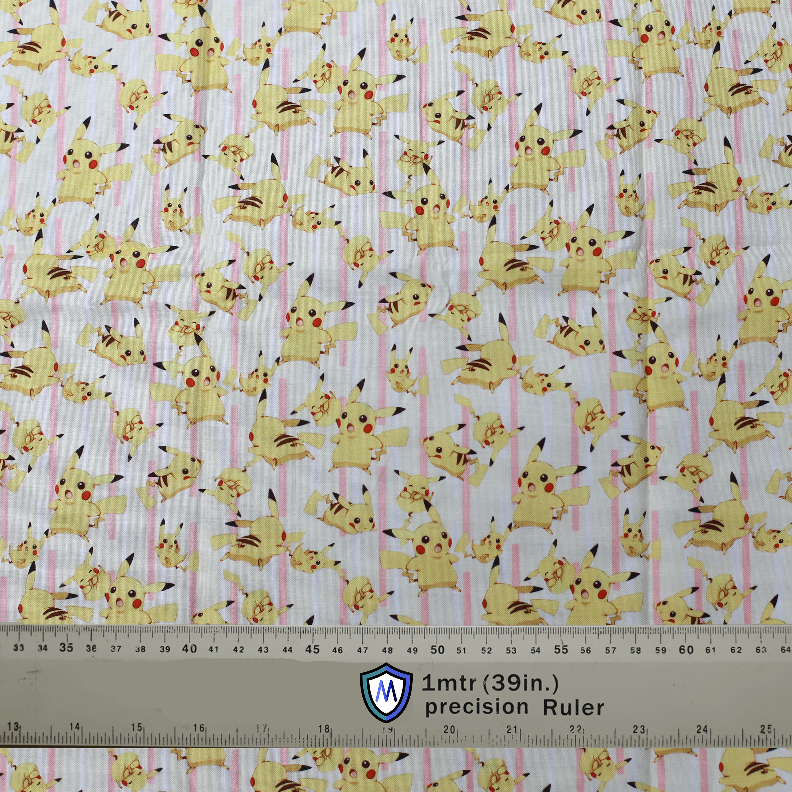 Fabric sample with Pikachu and lightning bolts on a pink-striped background, used for Medicus Scrub Caps. 1-meter ruler included for scale.