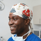 White scrub cap with colourful pirate ships and anchors pattern in navy and red