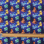 Close-up of Pokemon In Space Blue scrub cap fabric showing colorful Pokemon characters on starry blue background