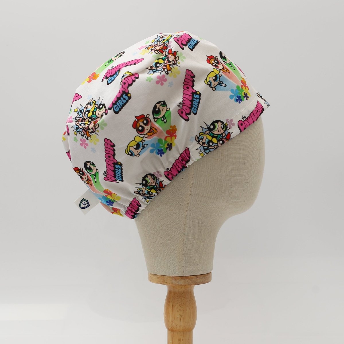 Custom Powerpuff Girls bouffant scrub cap by Medicus Caps featuring colorful cartoon characters and flowers on white fabric. Handmade to order and comfortable for medical professionals.