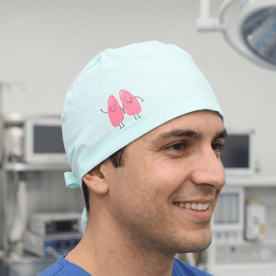 Light blue scrub cap with pink cartoon lung characters design for medical professionals