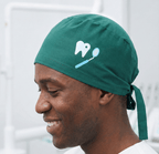 Green scrub cap with white tooth design shown in side profile view