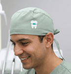 Green scrub cap with white tooth vinyl transfer design shown in side profile view