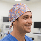 Purple Halloween pumpkin pattern scrub cap with orange accents and tie-back design