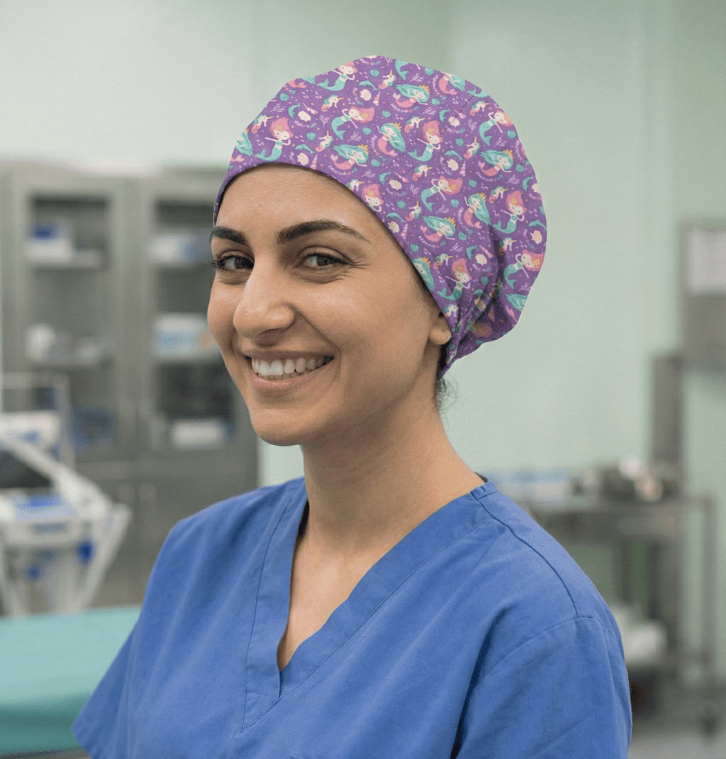 Purple mermaid-themed scrub cap with colorful sea creatures worn by smiling healthcare worker, side profile view