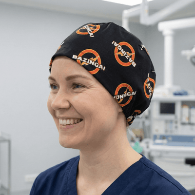 Black scrub cap with orange Bazinga logo pattern from Big Bang Theory TV show