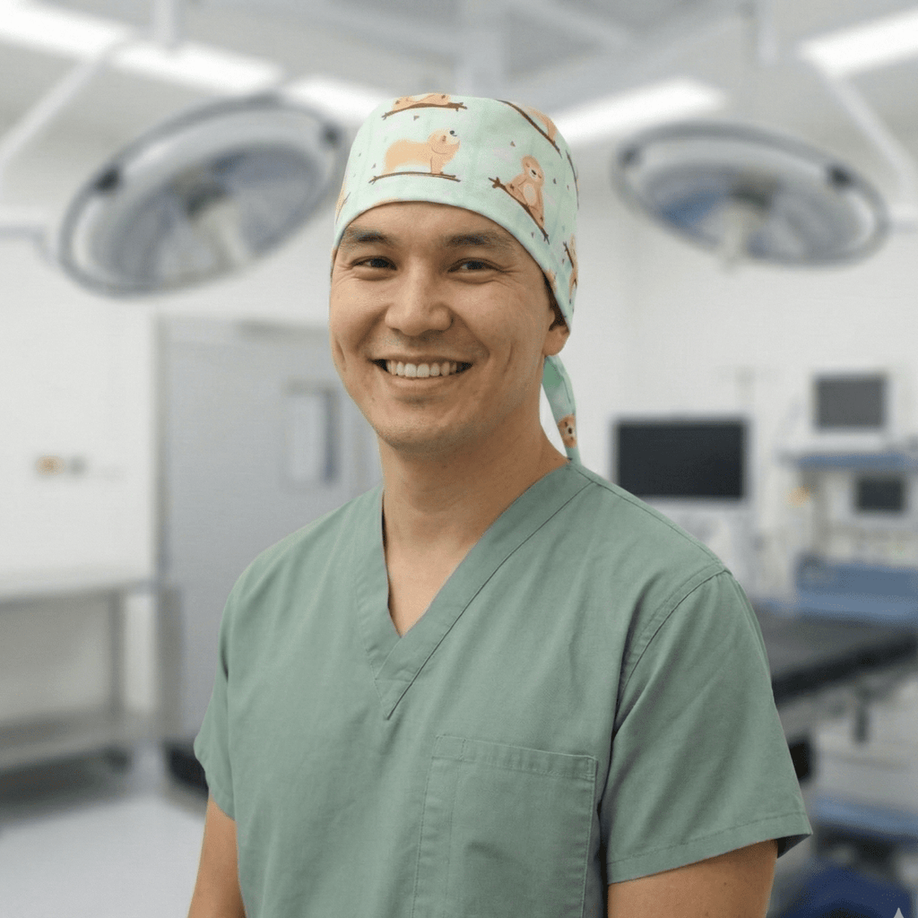 Healthcare worker wearing mint green Sloth Yoga Hangout scrub cap with orange sloth pattern in operating room
