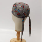 Back view of grey scrub cap featuring cute Spiderman characters with long tie ribbons