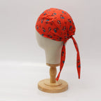 Side view of red scrub cap with cute Spiderman pattern and trailing tie ribbons