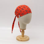 Red scrub cap with cute Spiderman pattern displayed on mannequin head, side profile view