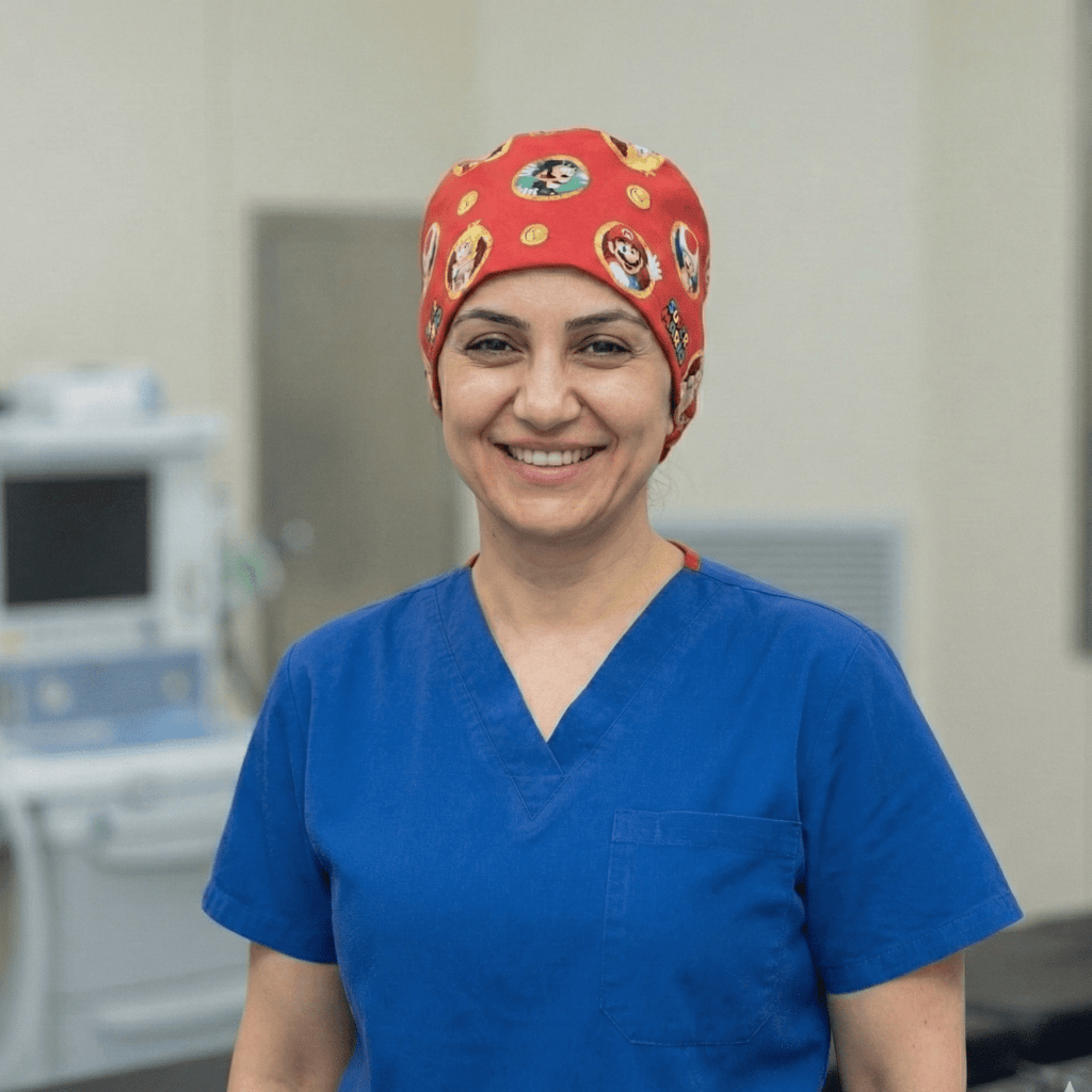Healthcare worker wearing red Super Mario patterned scrub cap with character icons, front view