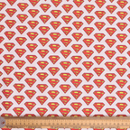 Close-up of Superman logo pattern on white scrub cap fabric with red and yellow shield designs
