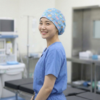 Healthcare worker wearing blue patterned Suture Self scrub cap, side profile view in medical setting