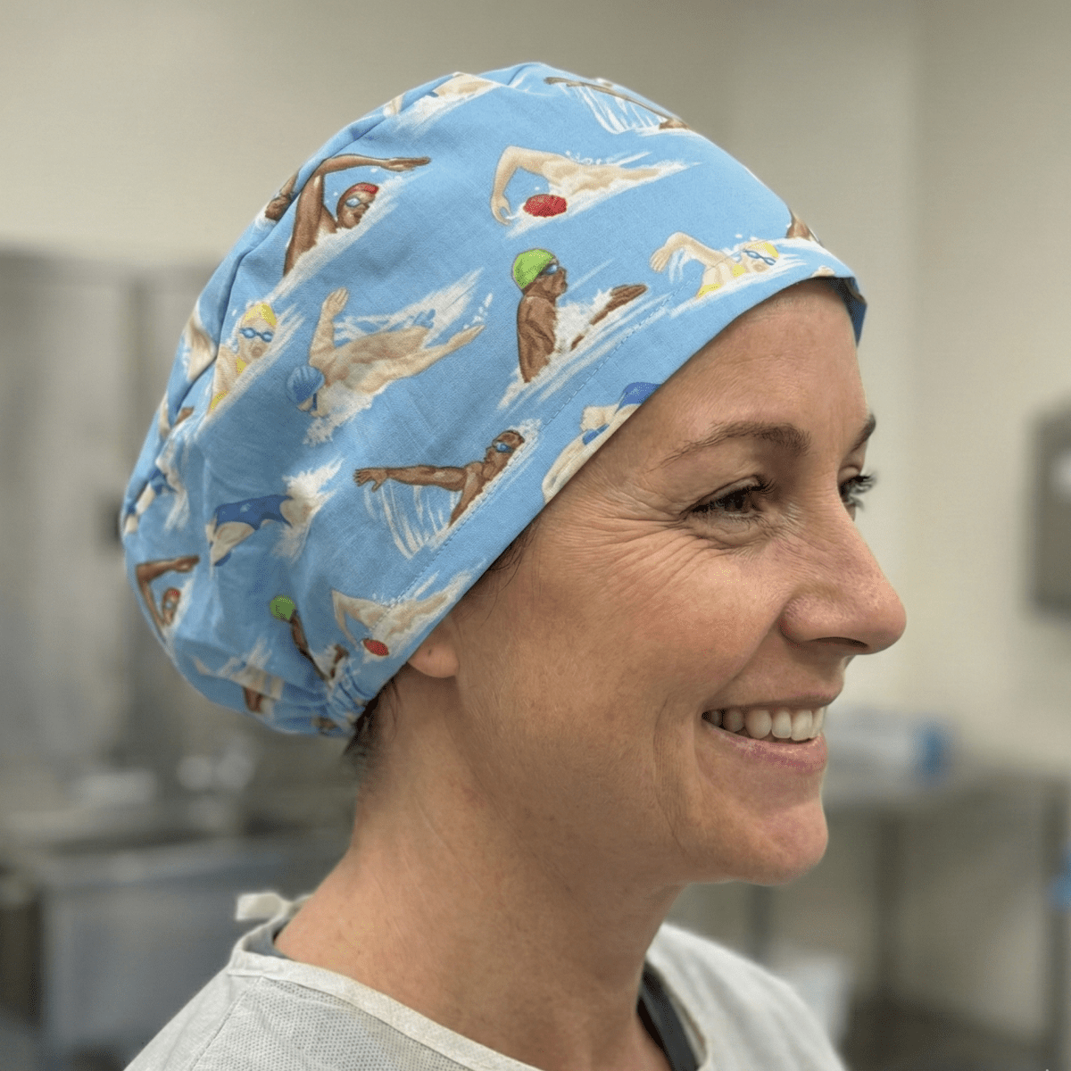 Light blue swimming pattern scrub cap with diving figures and goggles design