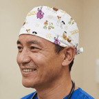 White Flintstones cartoon character pattern scrub cap with colourful prehistoric designs