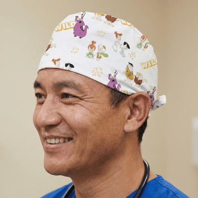 White Flintstones cartoon character pattern scrub cap with colourful prehistoric designs