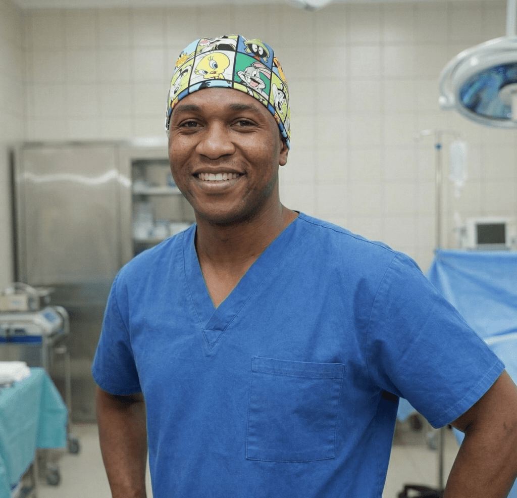 Healthcare professional wearing TV Cartoon Looney Tunes Characters Grid Green scrub cap in operating room setting