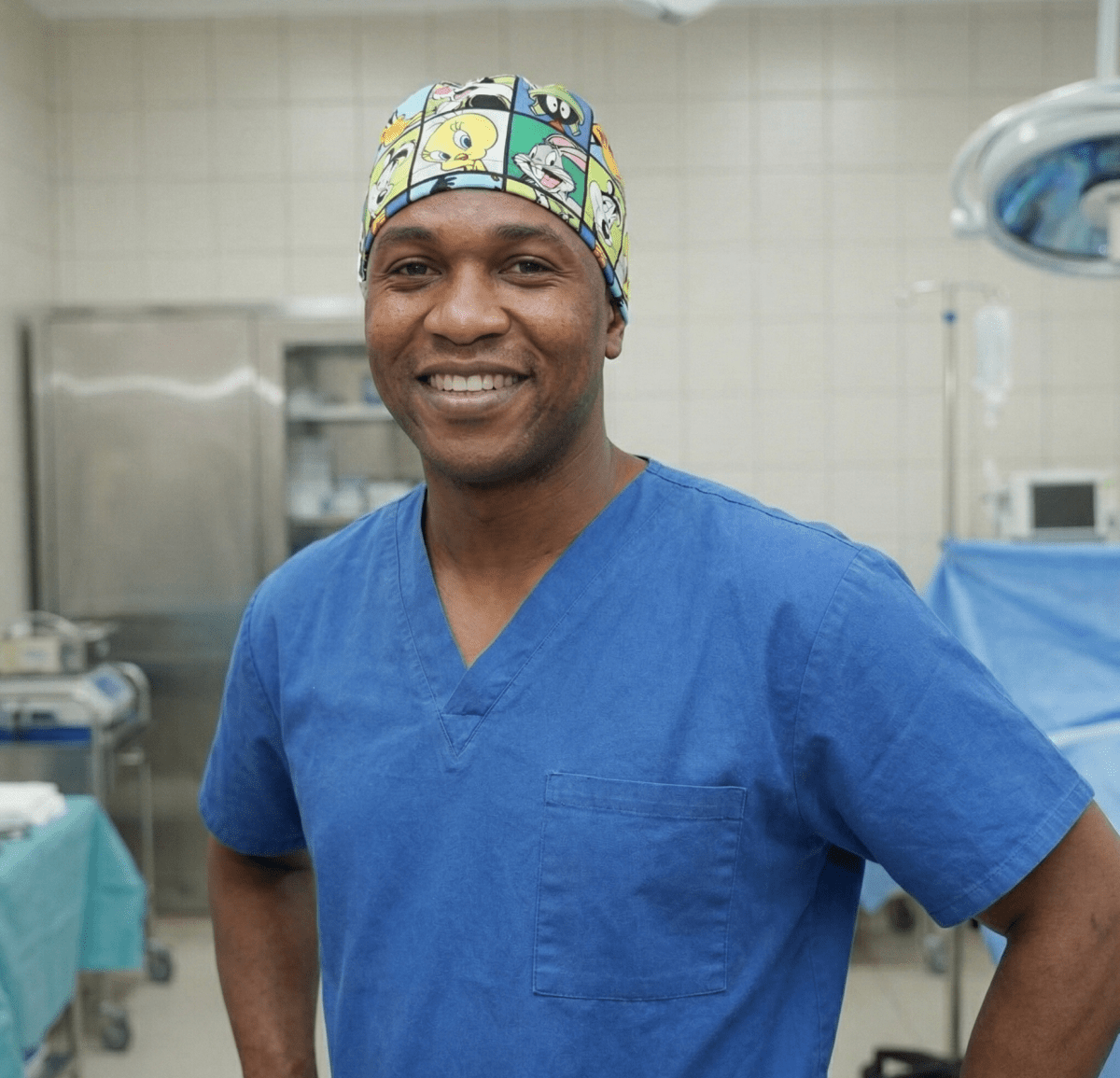 Healthcare professional wearing TV Cartoon Looney Tunes Characters Grid Green scrub cap in operating room setting