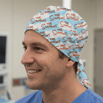 Light blue Simpsons logo pattern scrub cap with tie-back worn by smiling healthcare worker