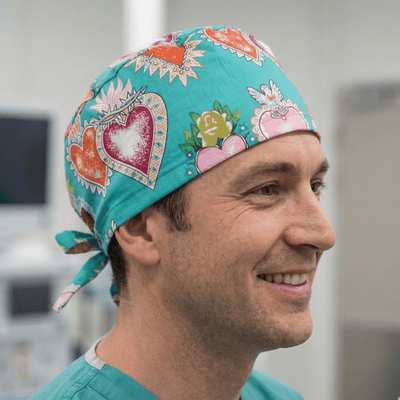 Turquoise tattoo heart pattern scrub cap with colourful decorative hearts and tie-back