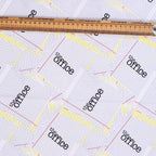 Close-up detail of The Office scrub cap showing scattered paper pattern with purple lines and yellow accents