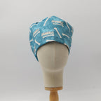 Back view of teal scrub cap with white bone and "Humerus" text pattern on mannequin head