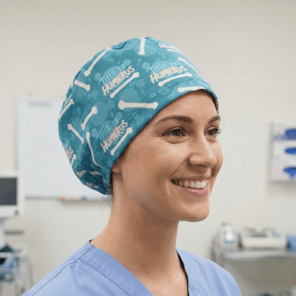 Turquoise scrub cap with white bone pattern and Humerus text worn by smiling healthcare worker