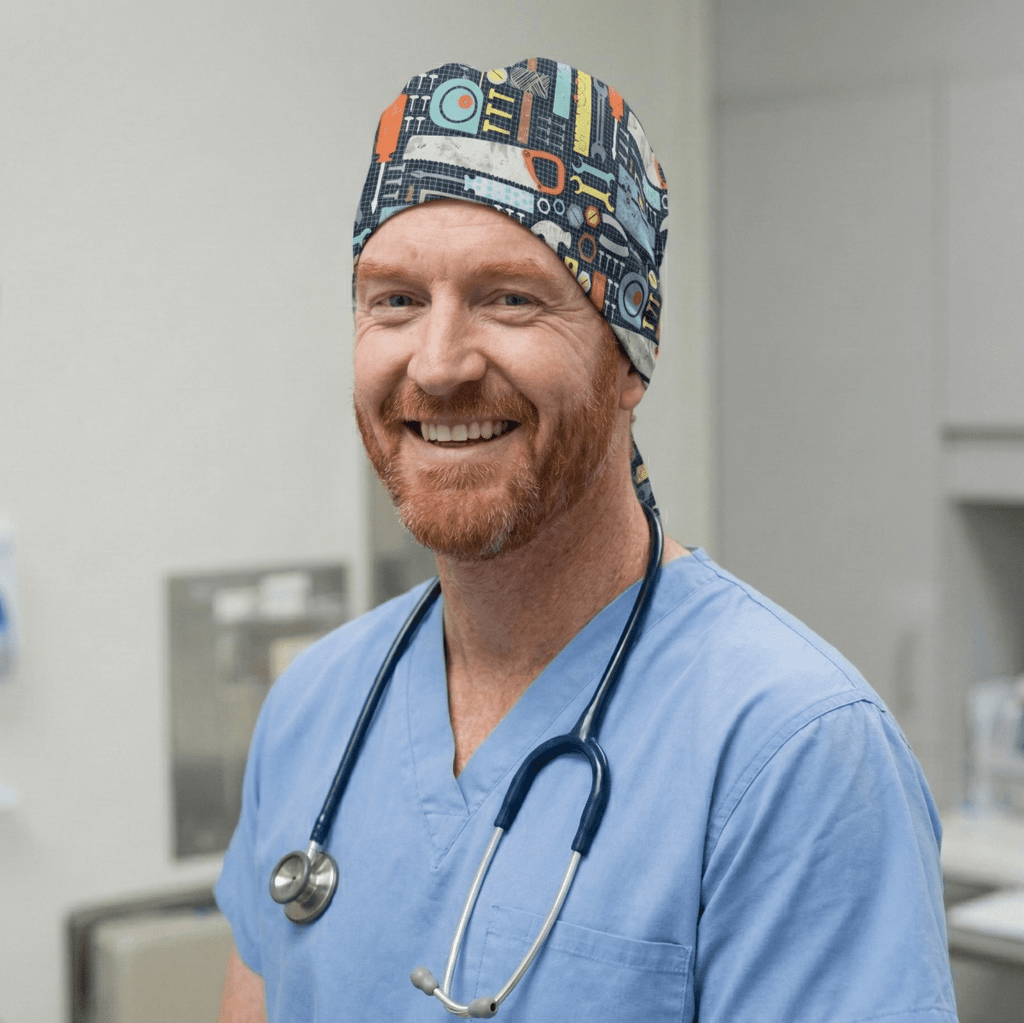 Healthcare worker wearing Tools Box Saw Hammer scrub cap with colorful tool pattern, front view