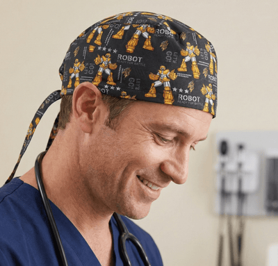 Robot pattern scrub cap with orange yellow robots on dark navy background tie-back design
