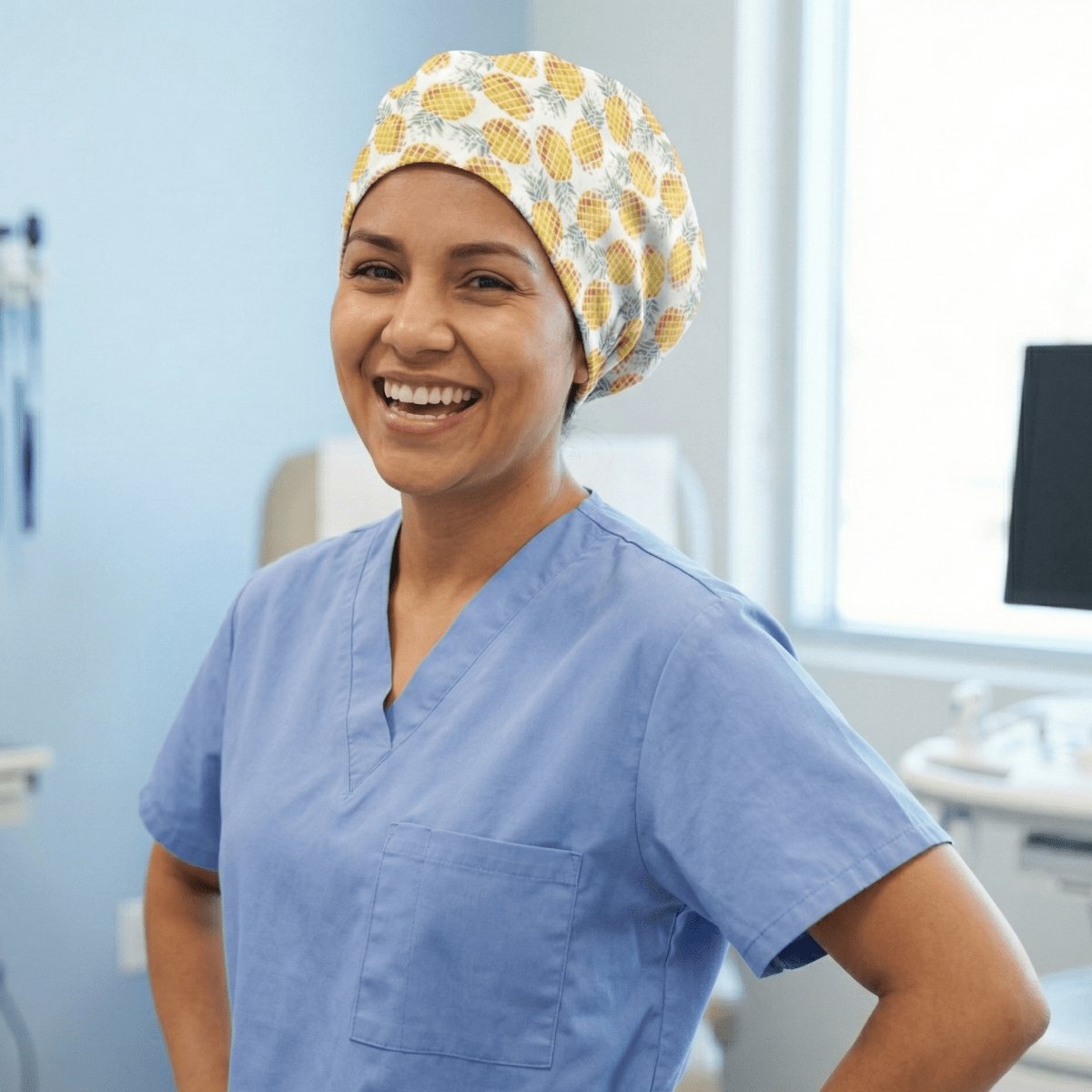 Healthcare worker wearing yellow pineapple pattern scrub cap, front view showing bright tropical design