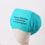 Turquoise scrub cap with personalized "Pawan Minhas Consultant Neurosurgeon" text shown on mannequin head