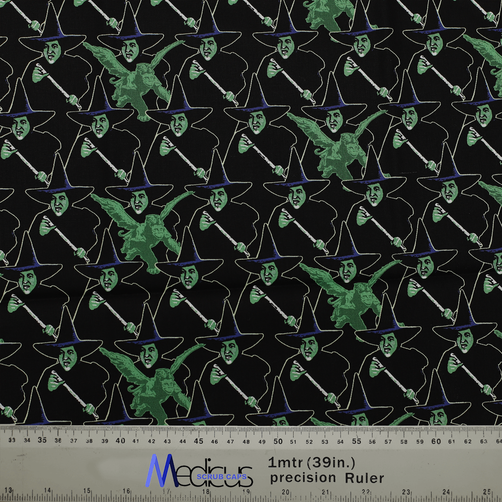Fabric with a witch pattern for Medicus Scrub Caps, featuring green and black witches on a dark background with a ruler for scale.