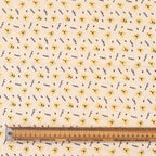 Close-up fabric detail of Winnie the Pooh scrub cap showing yellow bear faces and "HAPPY" text pattern