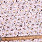 Close-up detail of pink Winnie the Pooh Christmas scrub cap fabric with Pooh and Eeyore pattern