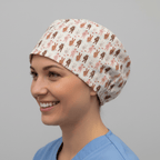 White scrub cap with pink and brown peace sign pattern worn by smiling healthcare worker
