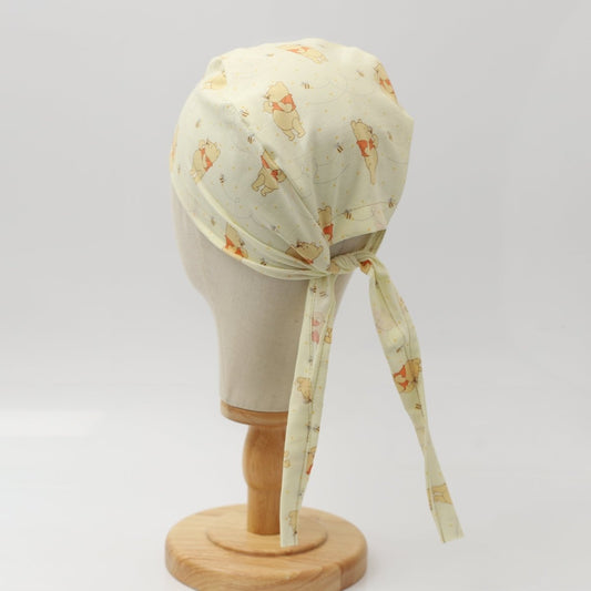 Custom yellow scrub cap by Medicus Caps featuring animal print pattern. Handmade surgical cap with ties, made to order.
