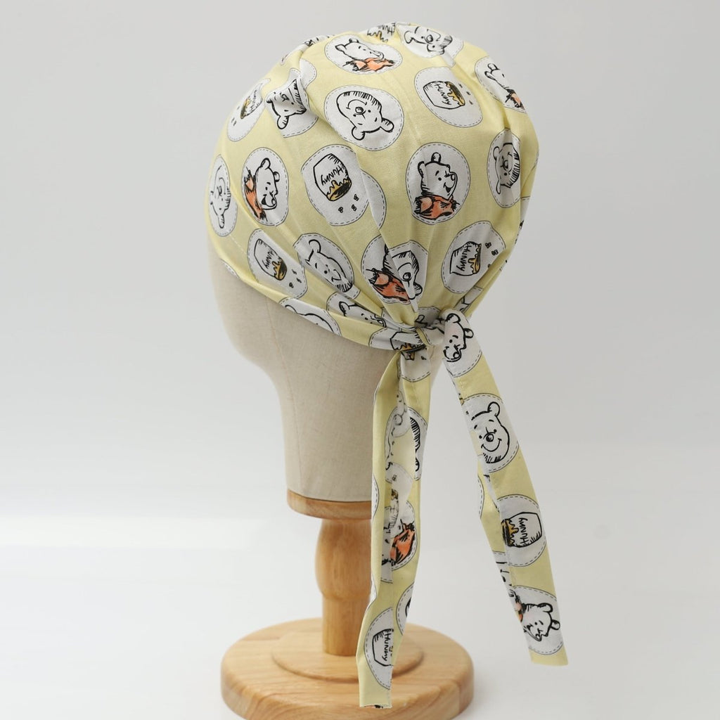 Back view of yellow custom scrub cap featuring cartoon faces design, handmade by Medicus Caps