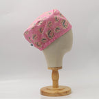 Pink scrub cap with eyeglasses pattern shown from side angle on mannequin head display