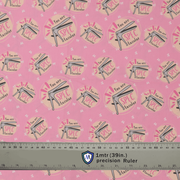 Pink Medicus Scrub Caps fabric with a speculum pattern and "You are SPECtacular" text, alongside a ruler for scale.