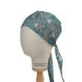 A Medicus Scrub Caps mannequin head displays the Abstract Jungle Tooth Teeth Scrub Cap, capturing dentistrys playful charm with cartoon teeth, toothbrushes, and dental tools on a teal background.