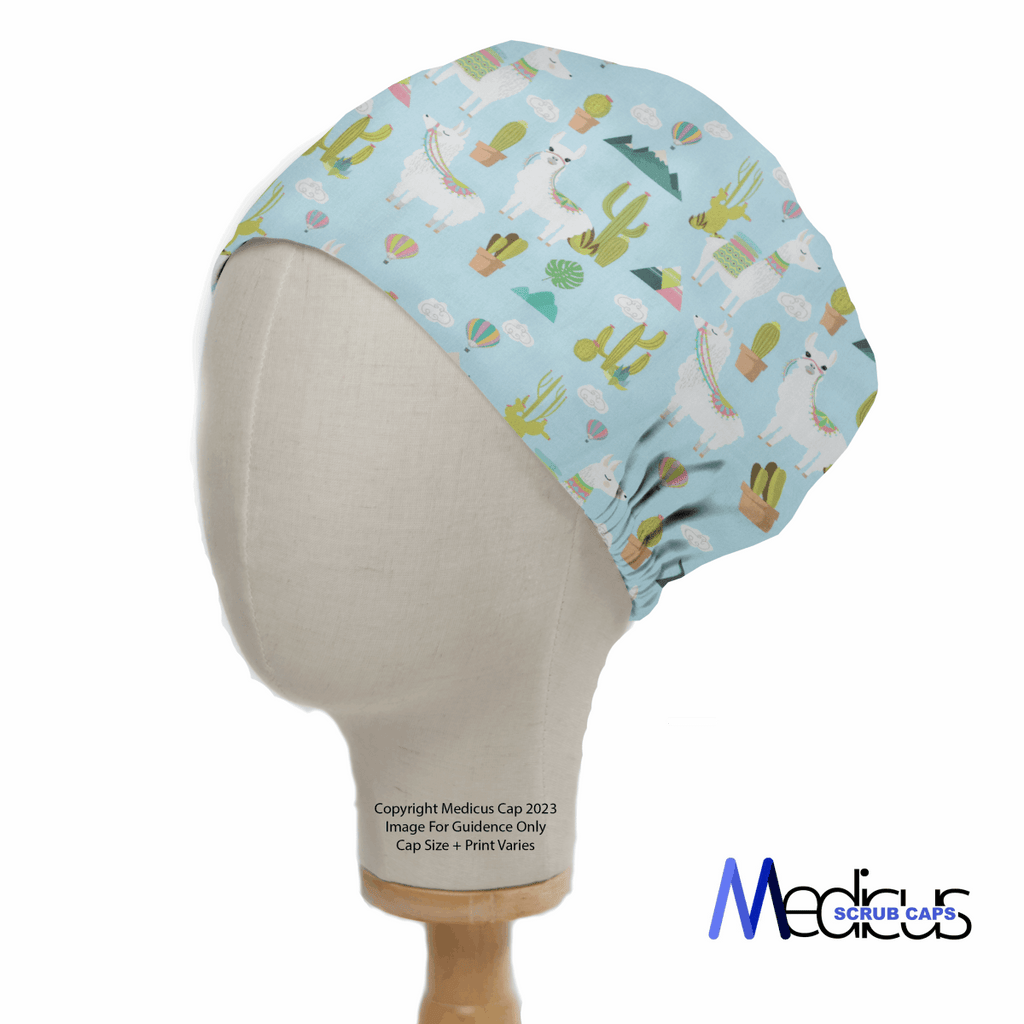 A mannequin head models the Alpaca Mountain Blue Theatre Cap by Medicus Scrub Caps, featuring llamas and cacti on a light blue backdrop. This fitted cap ensures ultimate comfort with its inclusive design, and an elegant logo is placed at the bottom right corner.