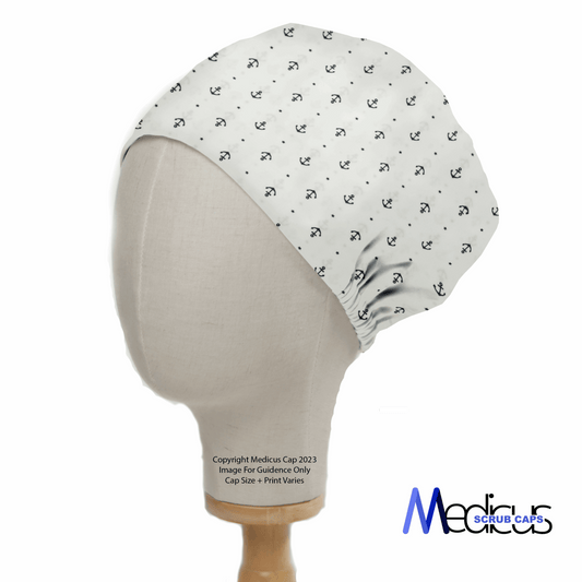 A mannequin head displays the Anchors On Ivory Scrub Cap by Medicus Scrub Caps, featuring small anchor patterns. The cap offers inclusive sizing with slight elasticity at the back and showcases the brands logo in the bottom right, highlighting sustainable healthcare fashion.