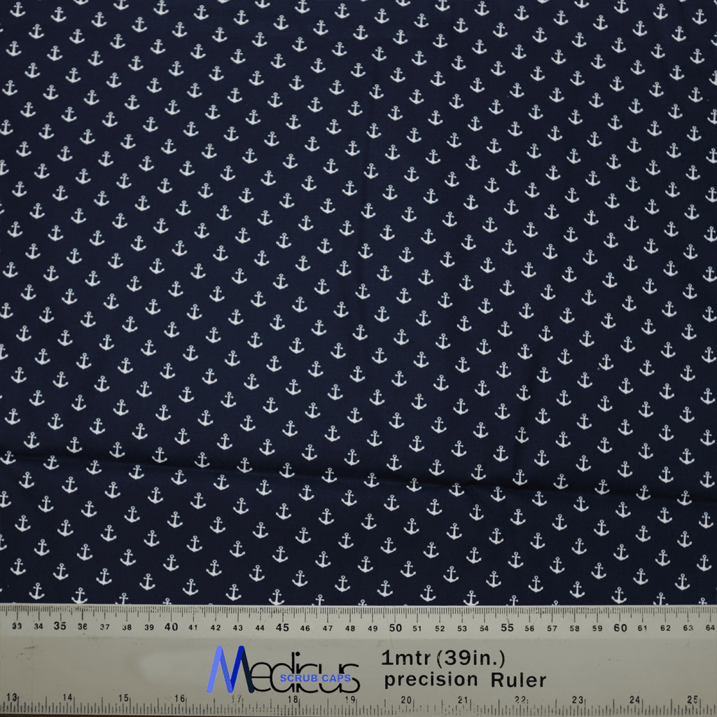 The Anchors On Navy Scrub Cap by Medicus Scrub Caps showcases a pattern of white anchors on dark blue fabric, designed to be eco-friendly and reusable. A ruler with centimeters and inches is visible below, partly revealing the Medicus label.