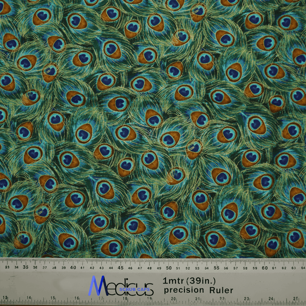 A vibrant close-up of eco-friendly fabric with a peacock feather design in green, blue, brown, and white. A ruler shows centimeter and inch measurements, ideal for crafting the Animal Print Peacock Scrub Cap by Medicus Scrub Caps.