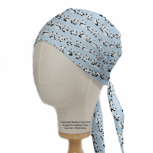 A mannequin head wears the Medicus Scrub Caps Baby Pandas On Blue Scrub Cap, displaying cute cartoon pandas on a light blue fabric. This reusable, eco-friendly cap features fabric ties at the back and is presented against a plain white background.