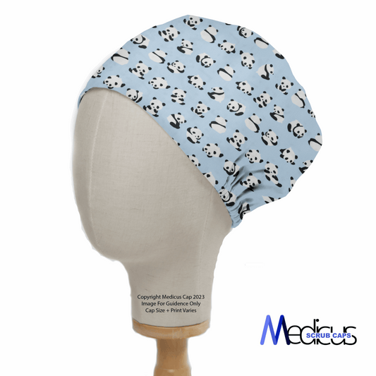 A mannequin head sports the eco-friendly Baby Pandas On Blue Scrub Cap with a cute panda print on light blue fabric. Against a white backdrop, the reusable cap stands out, and the Medicus Scrub Caps logo is gracefully placed at the bottom right.