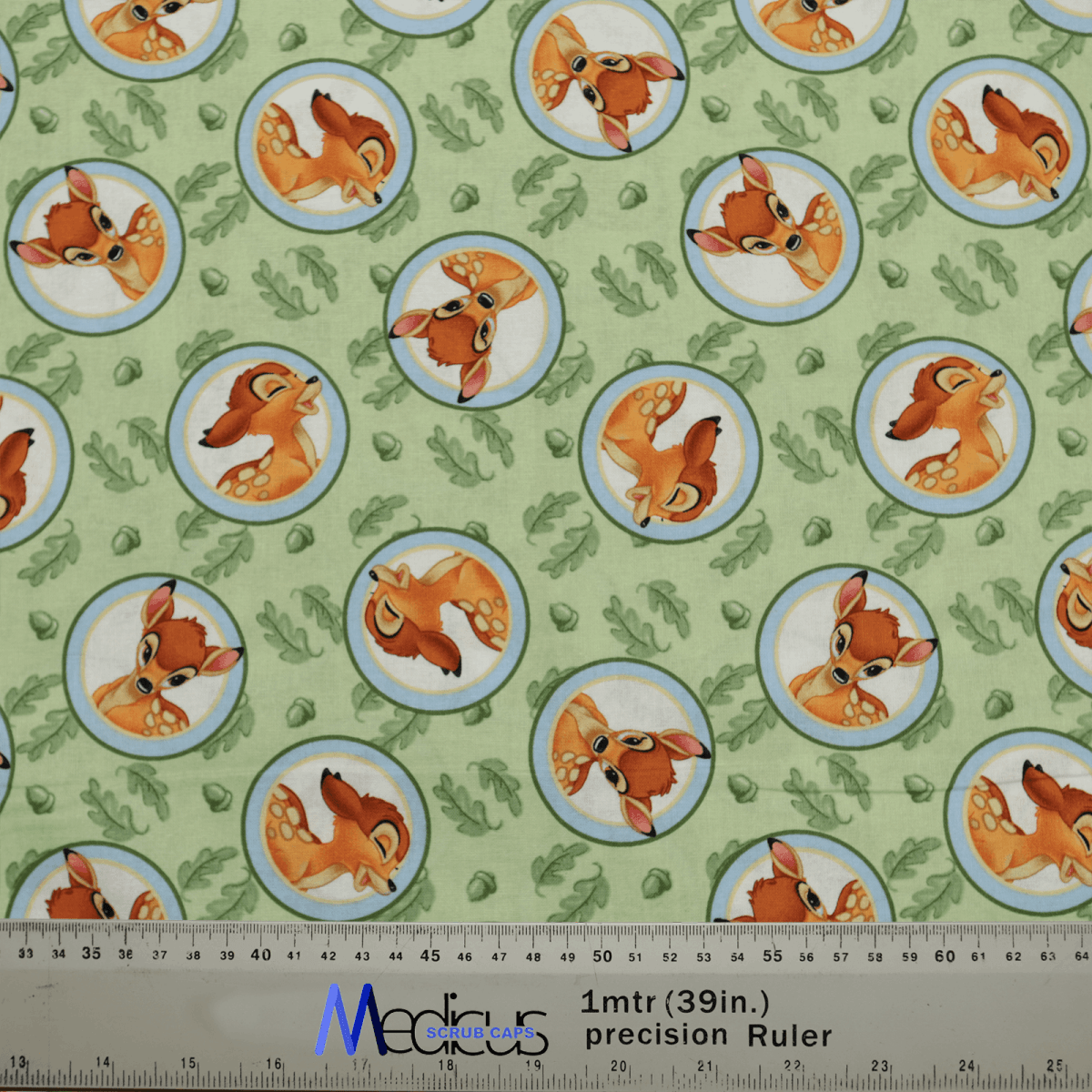 The Bambi Laughing On Green Scrub Cap by Medicus Scrub Caps features cartoon deer heads in circular frames, whimsically inspired by Bambi, with occasional footprints and plants for added charm. A ruler at the bottom shows dimensions in inches and meters, perfect for an eco-friendly design.
